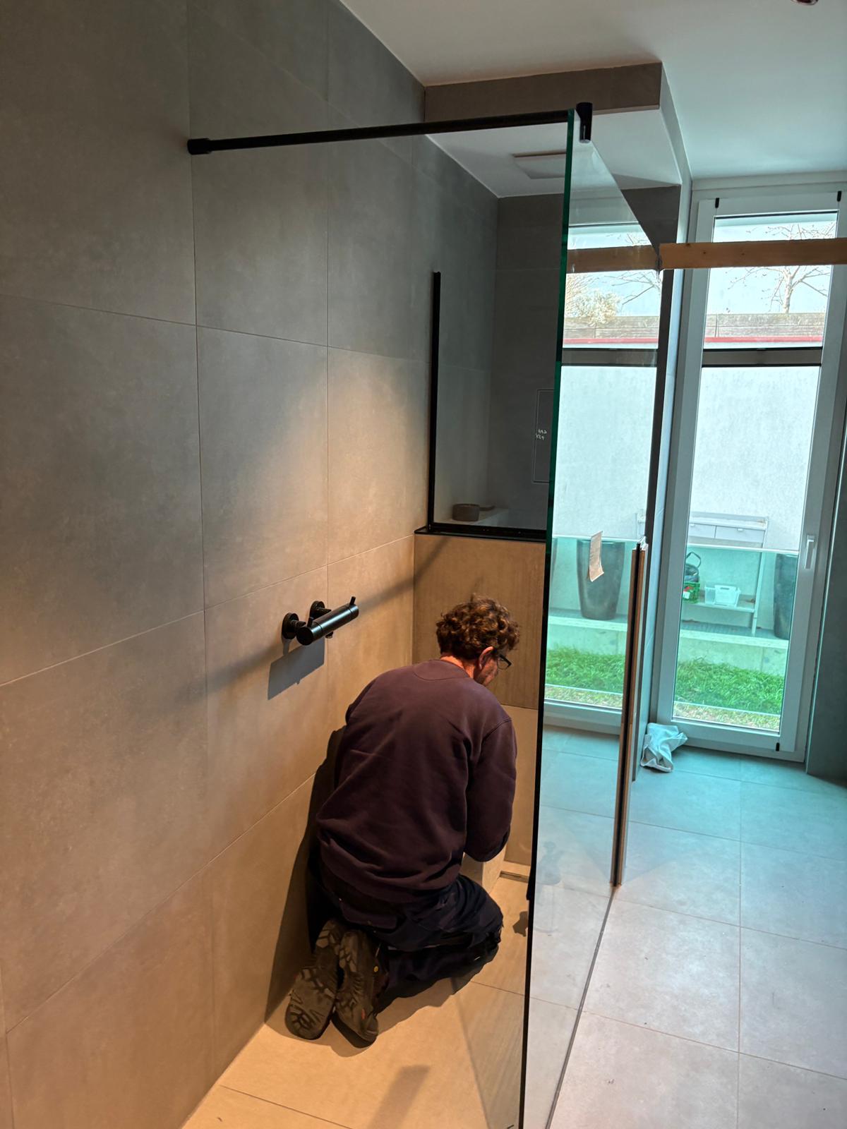 Monteur bei der Fertigstellung der Dusche