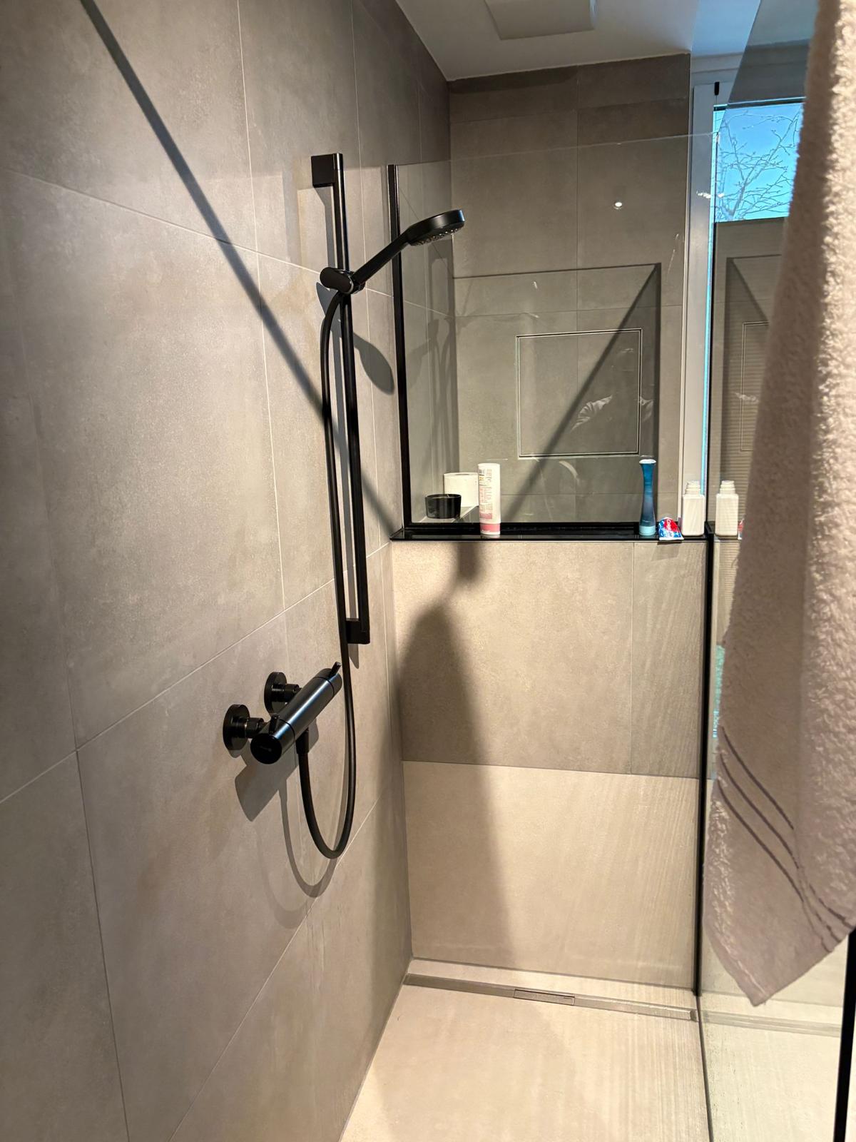 Fertige Walk-in-Dusche mit schwarzen Armaturen